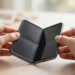 Hands opening a foldable smartphone to inspect the inner display crease